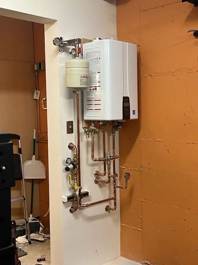 Plumbing technician inspecting water heater connections in Albany